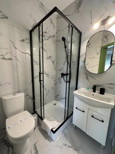 a bathroom with a shower and a toilet and a sink at MILIA wine & event resort in Dunajský Klátov