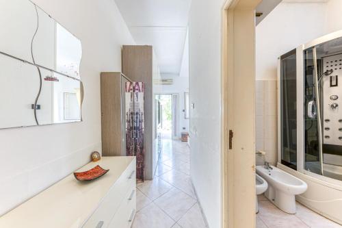 La salle de bains blanche est pourvue de toilettes et d'un lavabo. dans l'établissement Casa Luna, à Torre Suda
