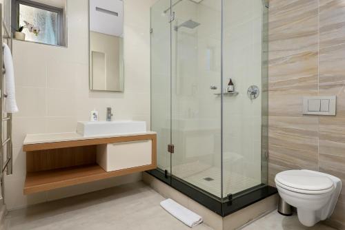 a bathroom with a shower and a toilet and a sink at Crystal Towers 212 in Cape Town