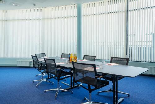 a conference room with tables and chairs and windows at Thon Hotel Ski in Ski
