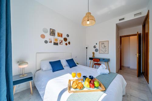 a bedroom with a bed with a tray of fruit on it at Heart Location & PARKING in Málaga