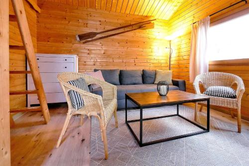 ein Wohnzimmer mit einem Sofa, Stühlen und einem Tisch in der Unterkunft Urlaub im Fischland Scharmützelsee in Wendisch Rietz
