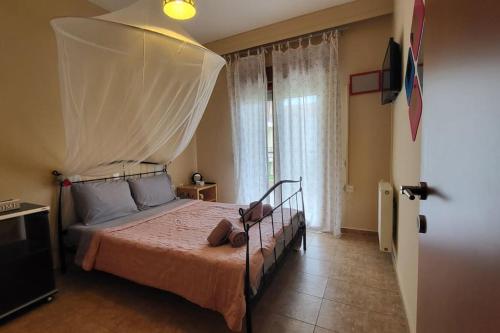 a bedroom with a bed with a mosquito net on it at Afytos Teo House in Kassandria