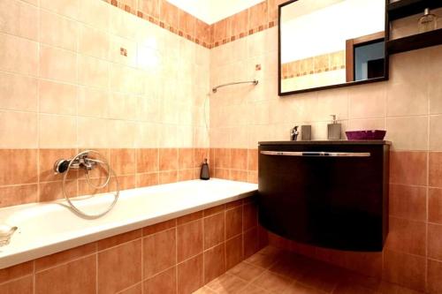 a bathroom with a tub and a sink and a mirror at Appartamento Oasi di Pontenuovo in Sermoneta