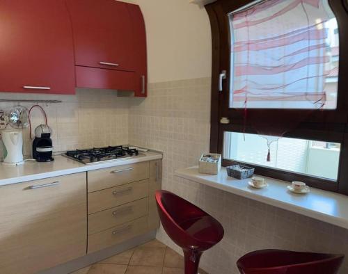 a kitchen with a stove and a red chair in it at Appartamento Oasi di Pontenuovo in Sermoneta