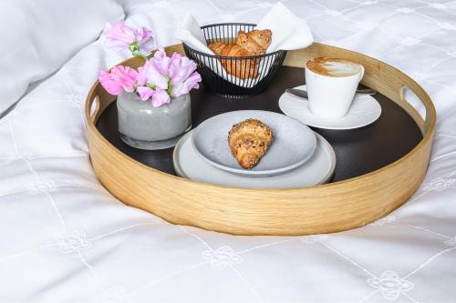 ein Tablett mit Essen, einer Tasse Kaffee und Blumen in der Unterkunft Appenzeller Huus Löwen in Gonten