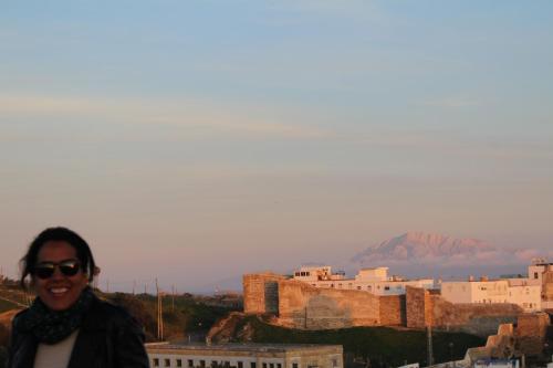 a woman standing in front of a city with a mountain at Room Tarifa in Tarifa