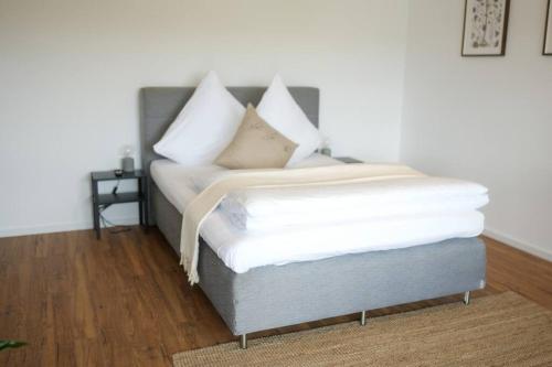 a bed with white pillows on top of it at Boho Stil Wohnung mit Flussblick nahe Stadtzentrum in Koblenz