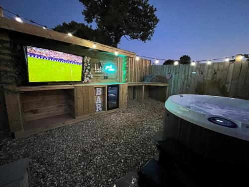 a backyard with a tv and a bath tub at Sycamore Cottage in Tenby