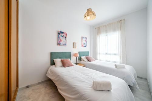 a bedroom with two beds and a window at Heart Location & PARKING in Málaga