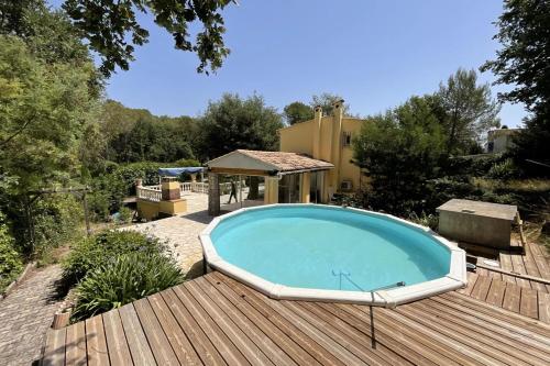 uma grande piscina num deque ao lado de uma casa em LES CIGALES Villa for 8 by Sunset Riviera Holidays em Roquefort Les Pins