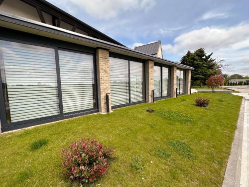 a house with roller blinds on the side of a yard at MILIA wine & event resort in Dunajský Klátov
