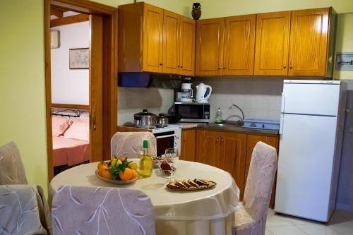 Kleidas Apartments في Thymianá: مطبخ مع طاولة عليها صحن من الفواكه