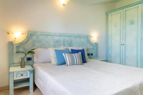 a blue bedroom with a large bed with pillows at Museddu Beach Residence in Cardedu