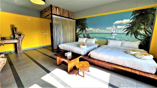 two beds in a room with a mural of the ocean at 墾丁興海灣民宿 in Manzhou