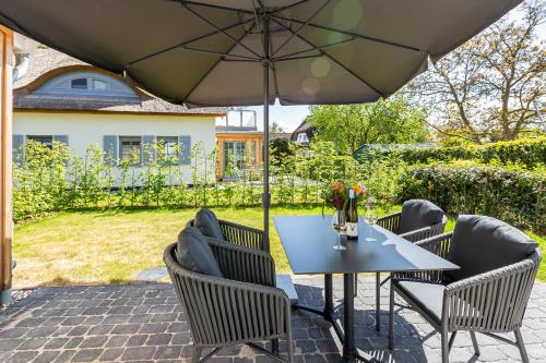a table with chairs and an umbrella on a patio at Windlooper 2 in Wieck