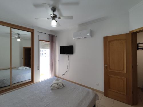 アルマカオ・デ・ペラにある1D Praia Mar - Casas & Papeisのベッドルーム(ベッド1台、テレビ、鏡付)
