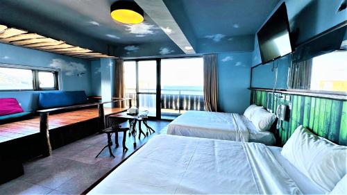 a hotel room with two beds and a balcony at Xinghaiwan B&B in Manzhou