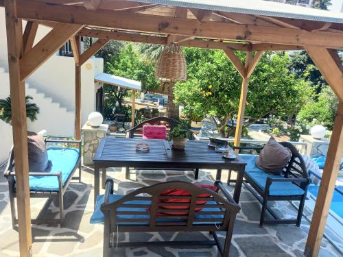 a table and chairs under a wooden pergola at Villa Rena in Batsi