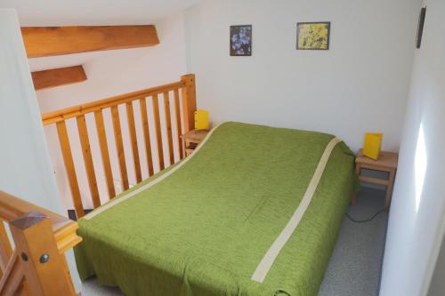 une chambre avec un lit vert et un escalier en bois dans l'établissement Nr 24 Vakantiehuisje Portiragnes Les Marines, à Portiragnes