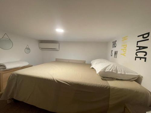 ein Schlafzimmer mit einem großen Bett mit weißer Bettwäsche und Kissen in der Unterkunft Studio mezzanine avec Terrasse privative cosy - REF MIMONT in Cannes