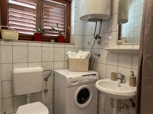 a bathroom with a washing machine and a sink at Family apartment Makarska in Makarska