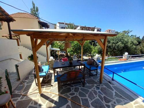 a wooden pergola sitting next to a swimming pool at Villa Rena in Batsi
