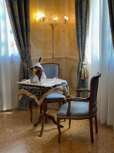 a dining room with two chairs and a table with a bowl of flowers at Hotel Villa Condulmer in Mogliano Veneto