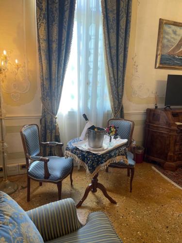 a living room with a table and chairs and a window at Hotel Villa Condulmer in Mogliano Veneto