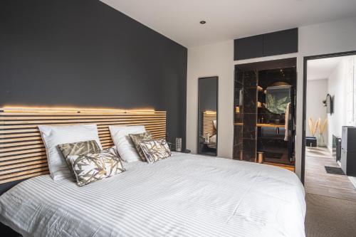a bedroom with a large white bed with pillows at Villa MaRisKa et son Spa, avec balcon in Ouistreham