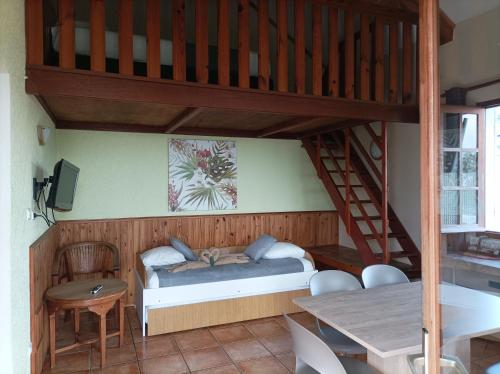 a bedroom with a bunk bed and a table at Hôtel L'Ecrin in La Plaine des Cafres