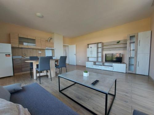 ソフィアにあるINTER EXPO APARTMENTの広いリビングルーム(テーブル付)、キッチンが備わります。