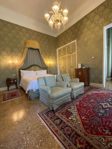 a bedroom with a bed and a couch and a chandelier at Hotel Villa Condulmer in Mogliano Veneto
