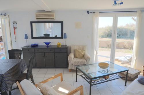 - un salon avec une table en verre et un miroir dans l'établissement Nr 90 Vakantiehuisje Portiragnes Les Marines, à Portiragnes