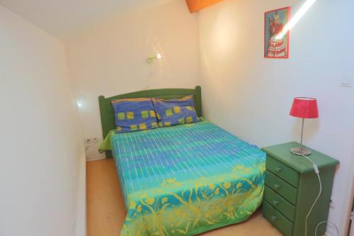 - une petite chambre avec un lit vert et une lampe dans l'établissement Nr 90 Vakantiehuisje Portiragnes Les Marines, à Portiragnes