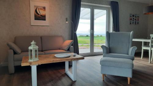 uma sala de estar com um sofá, uma mesa e uma cadeira em Ferienhaus Casa Baltica em Gelting