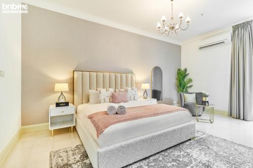 a bedroom with a large bed and a chandelier at bnbmehomes - Anbar Tower in Dubai