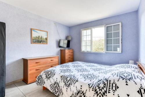 um quarto com uma cama, uma cómoda e uma janela em Gîte de l'aramont Dans Le Minervois em Laure-Minervois