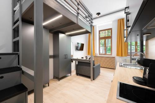 a kitchen with a staircase leading up to a living room at Servus Apartments by Homaris in Munich