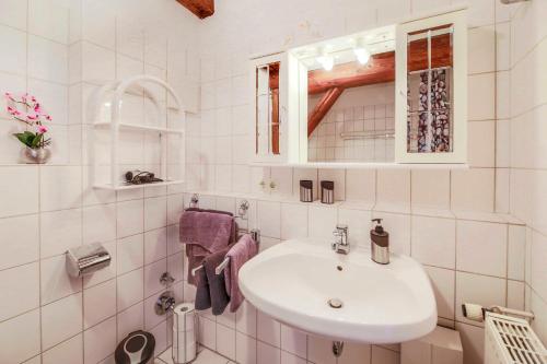 a white bathroom with a sink and a mirror at Ferienwohnung Johns in Bad Bevensen