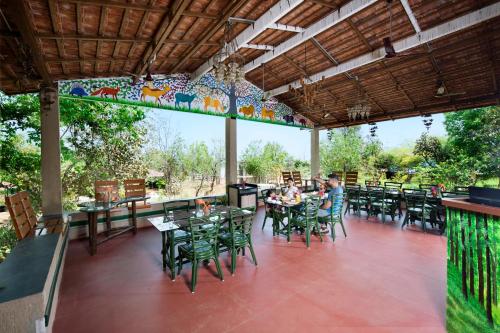 a restaurant with tables and chairs and people sitting at them at Tathastu Kanha in Kānha