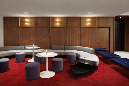a room with two tables and blue chairs and benches at Le Meridien Melbourne in Melbourne