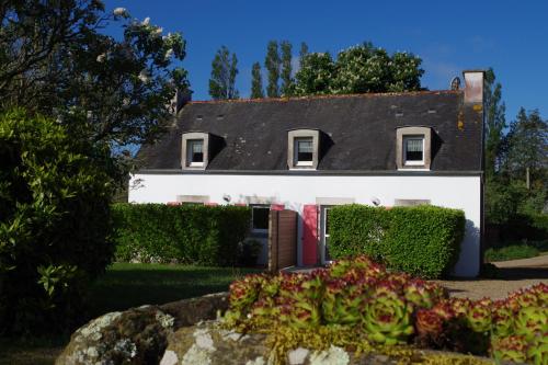a white house with a garden in front of it at Les Gîtes du Vallon du Trunvel in Plonéour-Lanvern