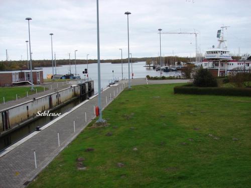 a park next to a river with a boat in the water at Christa & Wilfried Lammermann in Hooksiel