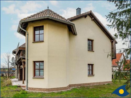 a white house with a tiled roof at Ferienwohnung Hornig in Garz-Usedom