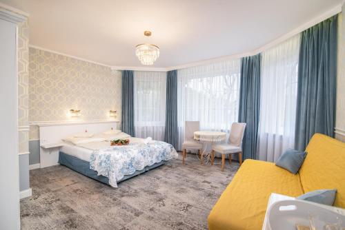 une chambre d'hôtel avec un lit, une table et des chaises dans l'établissement Villa Mare, à Łeba