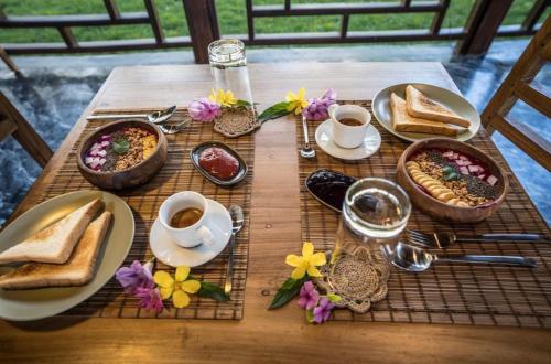 einen Tisch mit Teller mit Speisen und Tassen Kaffee in der Unterkunft Dylan’s Retreat in Lasikin