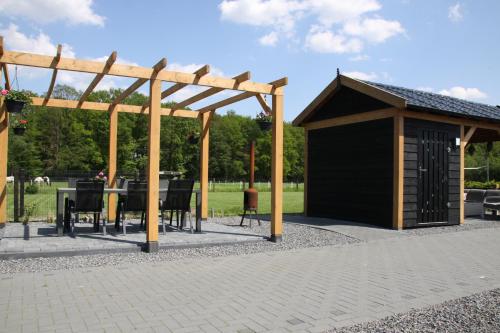a pavilion with a table and chairs in a park at B&B Hoeve de Veldmaat in Haaksbergen