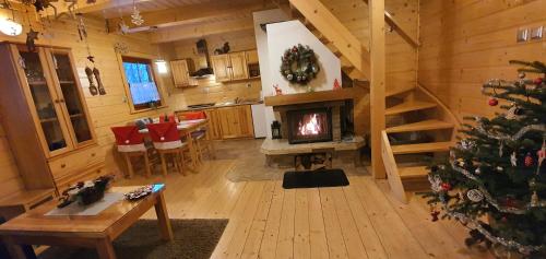 a living room with a christmas tree in a cabin at Domek Górski Promyk z kominkiem in Wisła