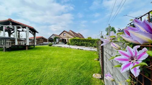 a yard with a fence and purple flowers at Les Sources d'Hon - Gîte & Espace wellness in Hon-Hergies